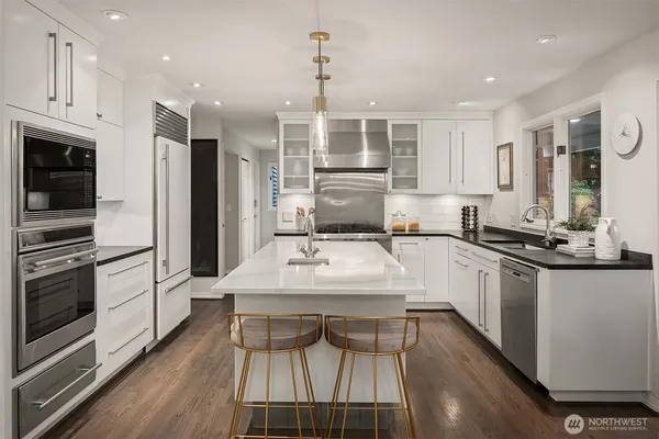 a kitchen with granite countertop a stove a sink and a refrigerator