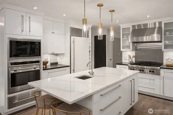 a kitchen with white cabinets and stainless steel appliances