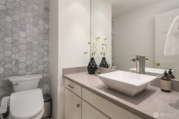 a bathroom with a granite countertop sink and a toilet
