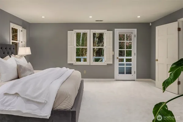 a spacious bedroom with a bed and glass window