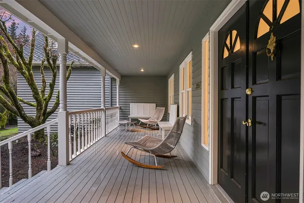 a view of a balcony with chairs and wooden floor