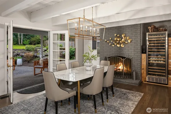 a dining room with furniture wooden floor a fireplace and a chandelier