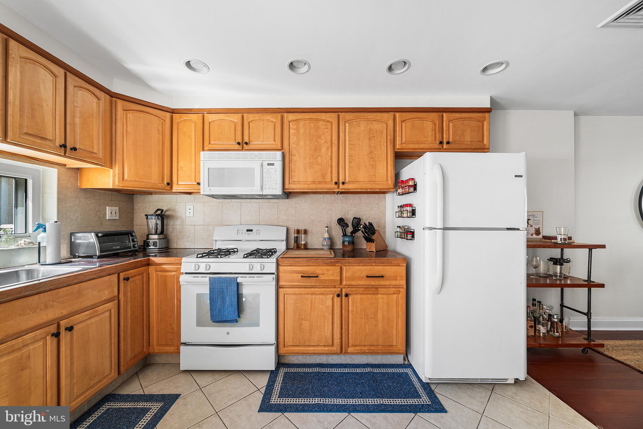 2520 Webster Street Philadelphia, PA 19146 - Photo 11 of 24 a kitchen with stainless steel appliances granite countertop a refrigerator sink stove and white cabinets