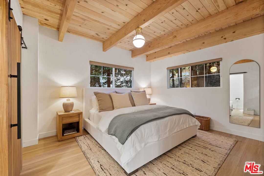 27643 West Shore Road, Unit 1 Lake Arrowhead, CA 92352 - Photo 21 of 31 a bedroom with a large bed and a chandelier