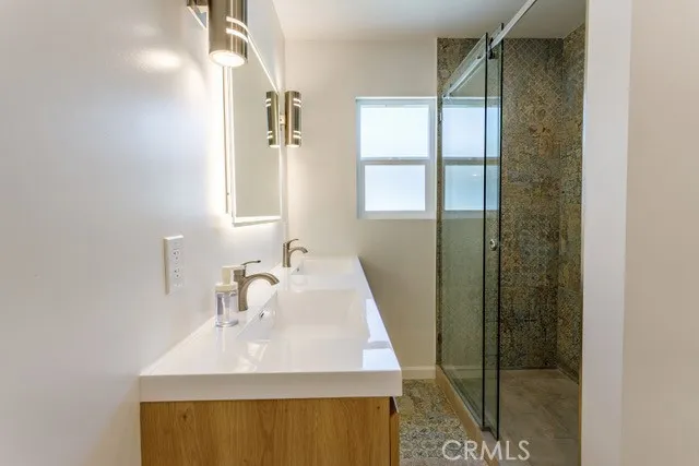 a bathroom with a sink a mirror and a shower