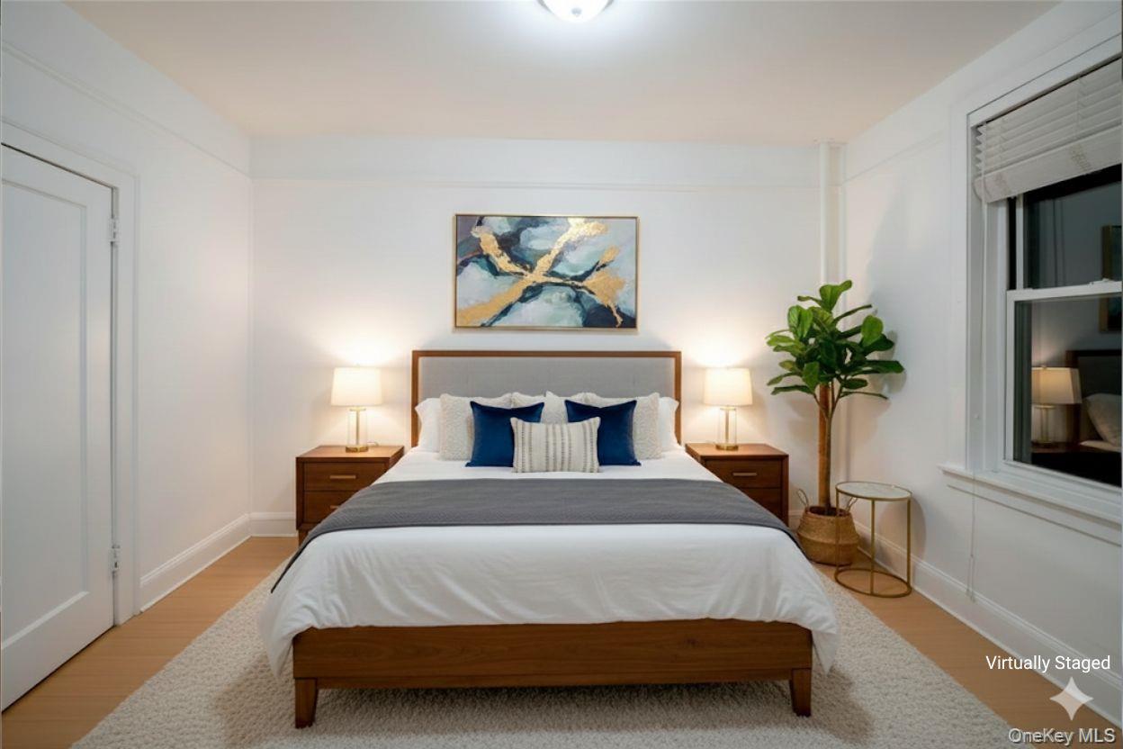 3775 64th Street, Unit 31 Queens, NY 11377 - Photo 11 of 18 a bedroom with a bed and a potted plant