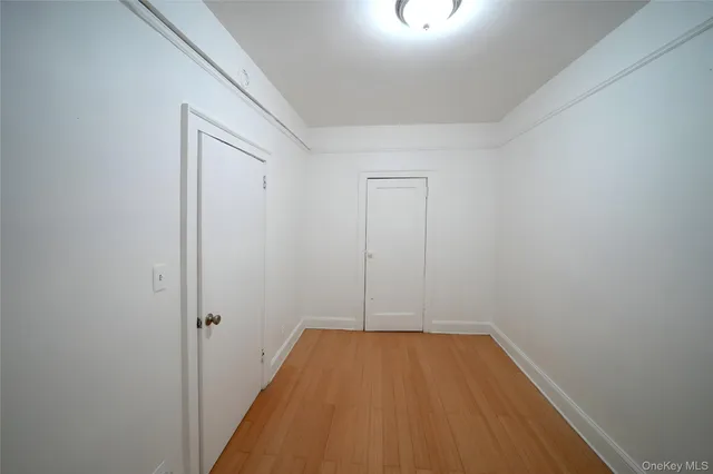a view of a room with wooden floor and a ceiling fan
