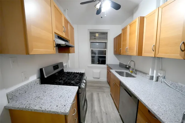a kitchen with stainless steel appliances granite countertop a sink a stove and a refrigerator