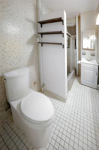 a white toilet sitting next to a bathroom sink and a shower