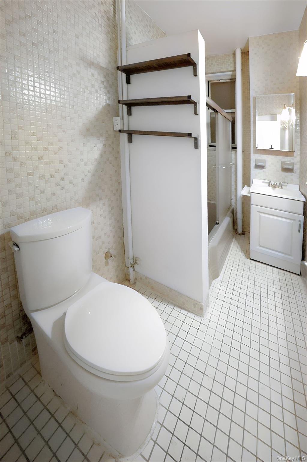3775 64th Street, Unit 31 Queens, NY 11377 - Photo 9 of 18 a white toilet sitting next to a bathroom sink and a shower