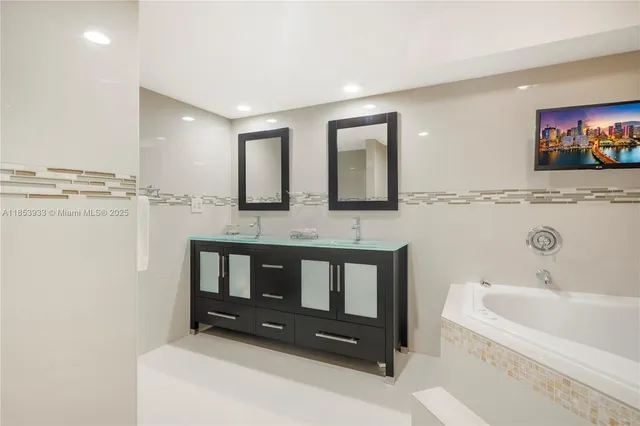 a bathroom with a tub a sink and a shower