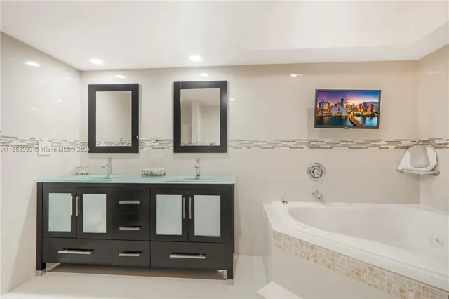 a bathroom with a bathtub a mirror and a sink