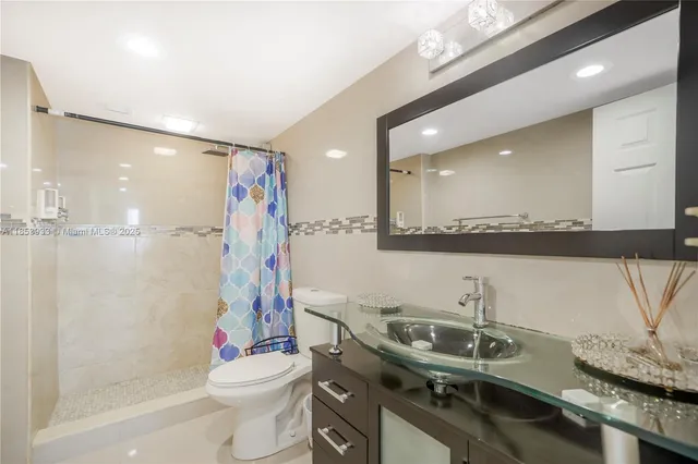 a bathroom with a sink a toilet and shower