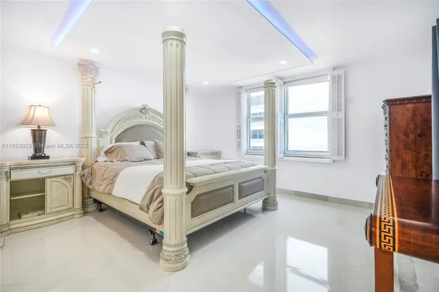 a bedroom with a bed and a dresser next to a window