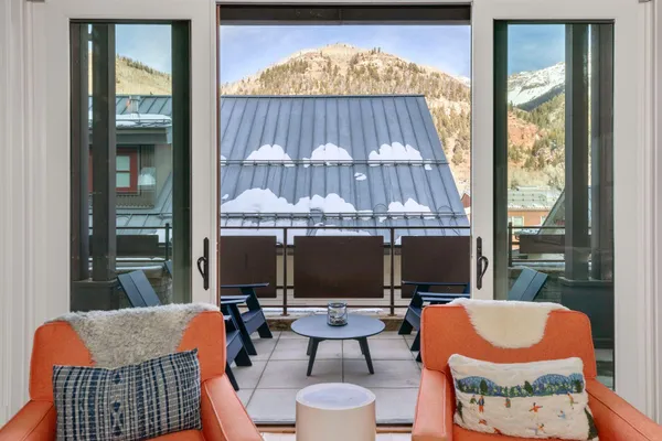 an outdoor sitting area with a tub and glass windows