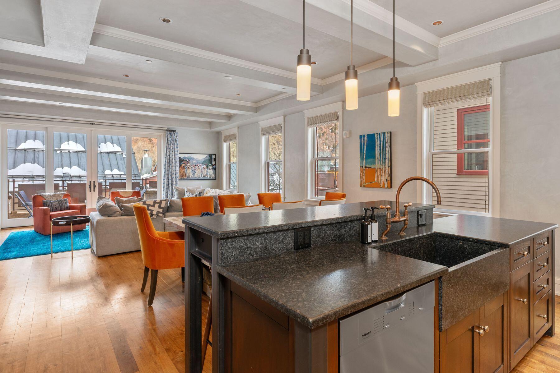 398 South Davis Street, Unit SW402 Telluride, CO 81435 - Photo 11 of 44 a kitchen with stainless steel appliances granite countertop a table chairs and a wooden floor