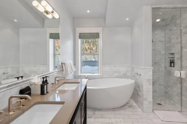 a bathroom with a tub a sink and mirror