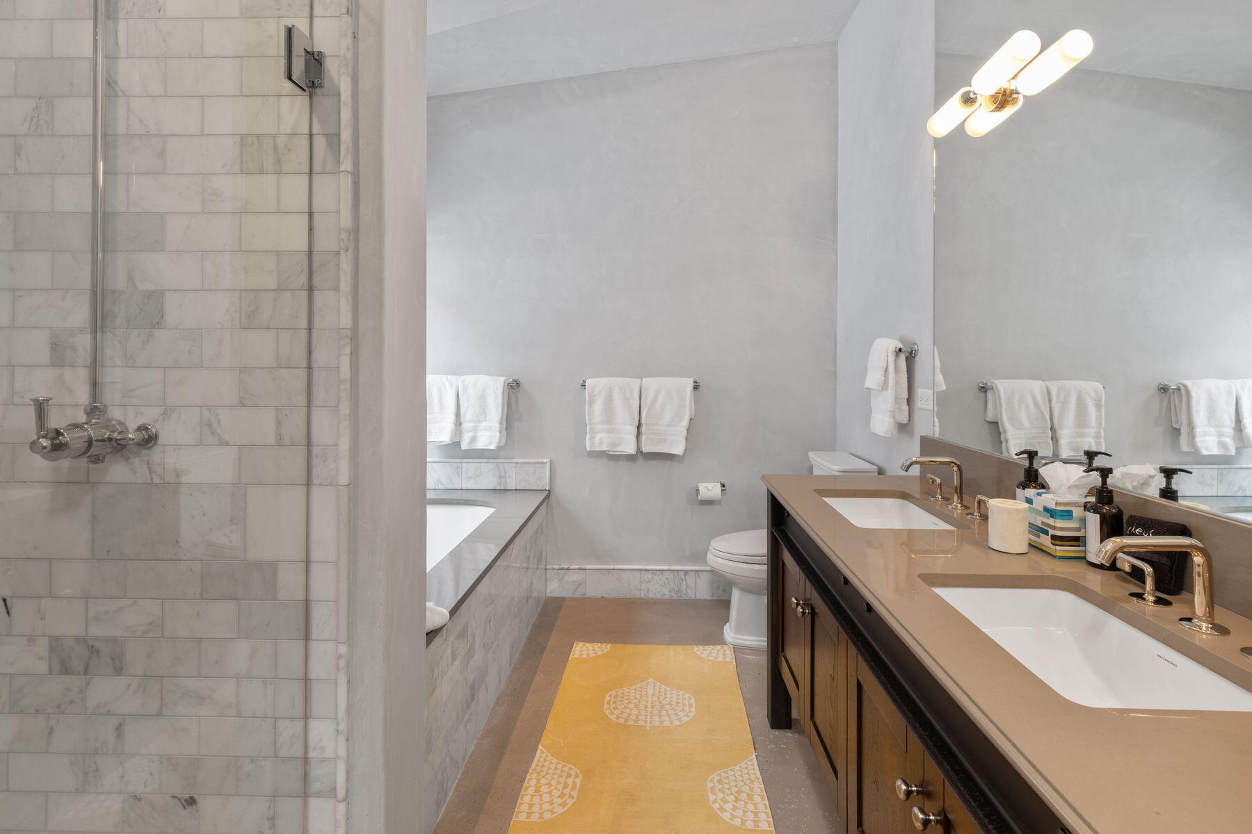 398 South Davis Street, Unit SW402 Telluride, CO 81435 - Photo 24 of 44 a bathroom with a double vanity sink a mirror and a bathtub