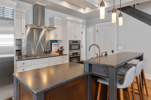 a kitchen with stainless steel appliances granite countertop a sink refrigerator and microwave