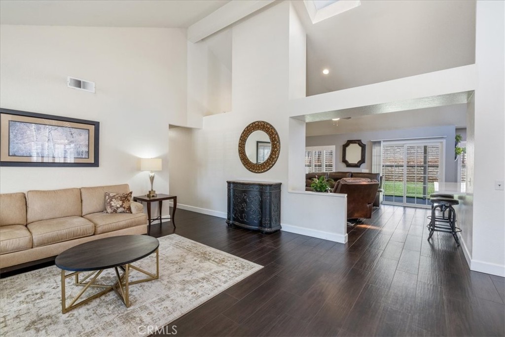 106 Bracebridge Court Riverside, CA 92506 - Photo 11 of 48 a living room with furniture a clock and a wooden floor