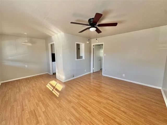 a view of a livingroom with wooden floor and a ceiling fan