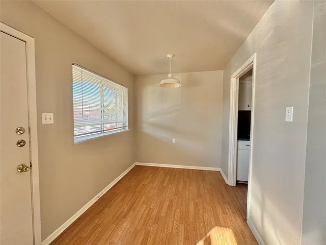 a view of a room with wooden floor and entryway
