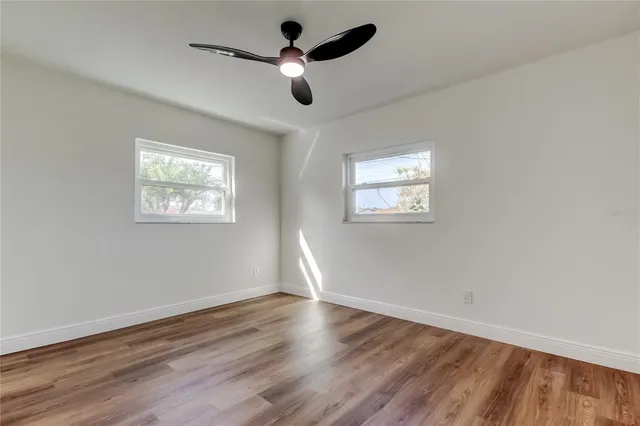 a view of empty room with wooden floor