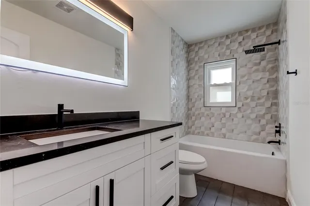 a view of kitchen with kitchen island wooden floor and refrigerator