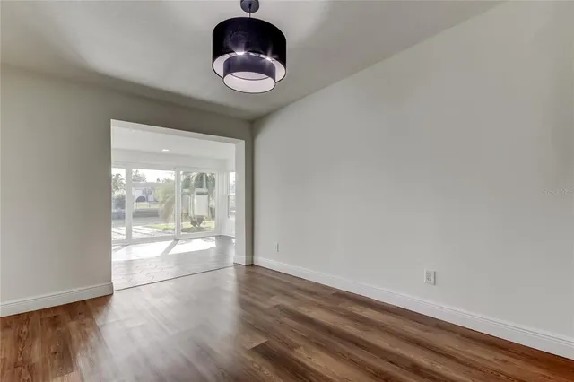 an empty room with wooden floor and a bathroom