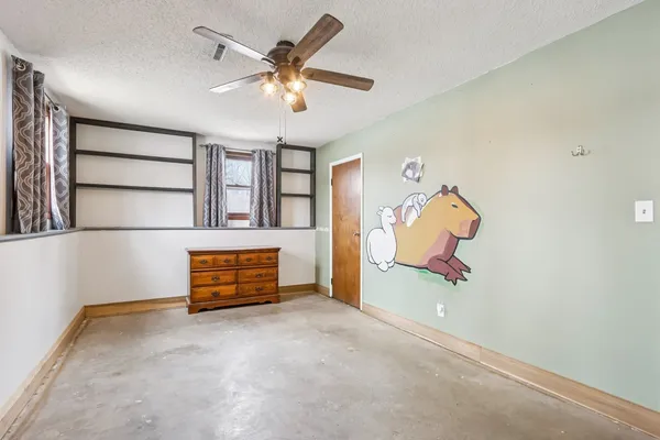 a view of a room with gym equipment and a chandelier