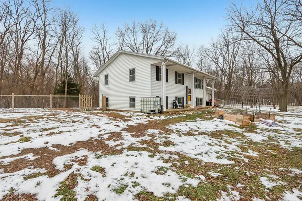 a view of a white house with a yard covered with snow in front of house
