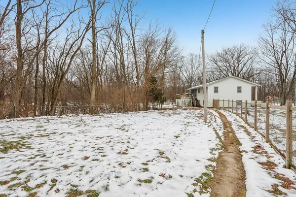 a view of a house with a yard covered in snow