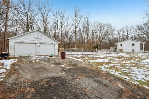 a view of a white house with a yard covered in snow