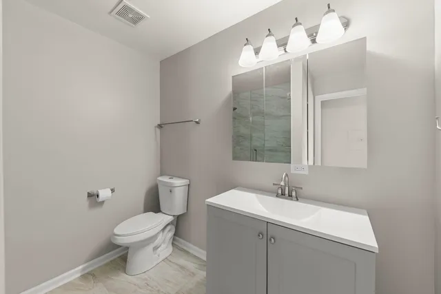 a bathroom with a sink mirror and toilet