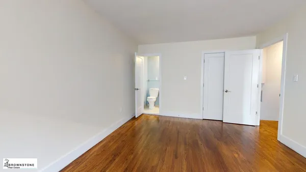 a view of a big room with wooden floor and windows