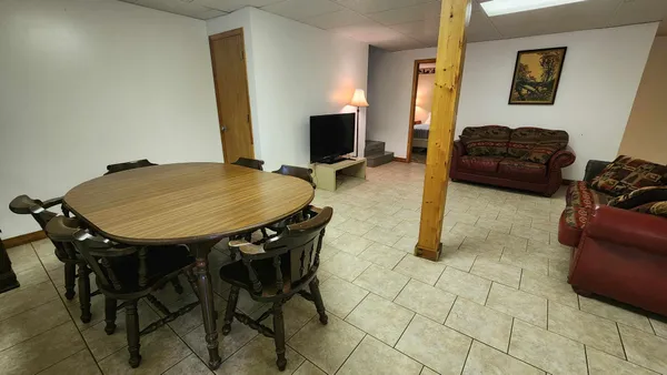 a living room with furniture a flat screen tv and a table