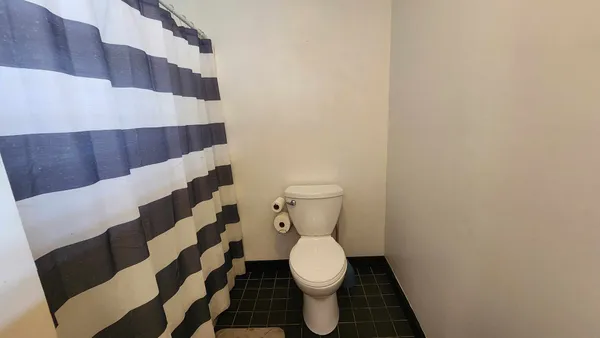 a bathroom with a toilet and a shower