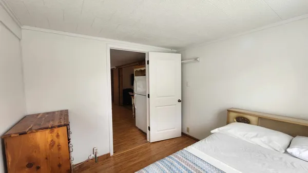 a bedroom with a bed and wooden floor