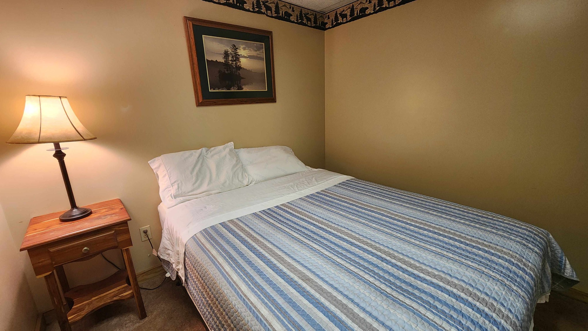 228 Bill Hunter Road Celina, TN 38551 - Photo 21 of 51 a bedroom with a bed and a lamp with the wooden floor