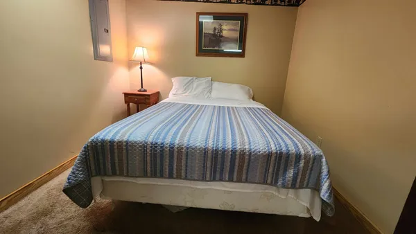 a bedroom with a bed and lamp on desk