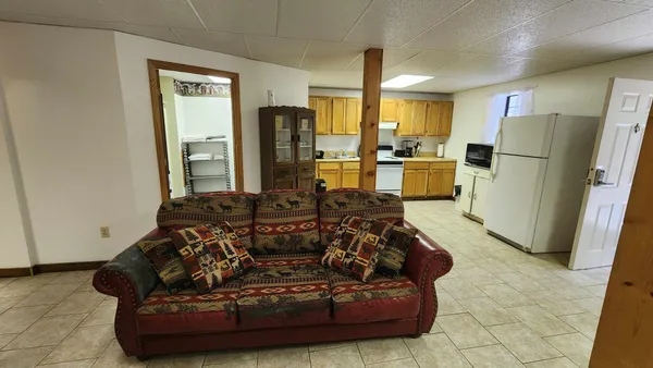 a living room with furniture windows and a refrigerator