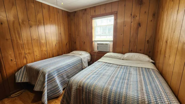 a bedroom with two beds and a window