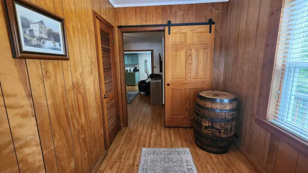 a view of a hallway with wooden floor and chair