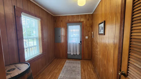 a view of a hallway with wooden floor and windows