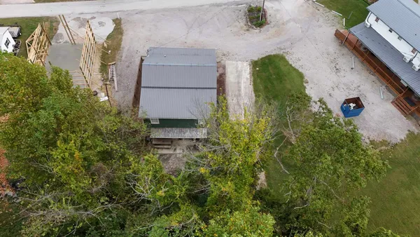 an aerial view of a house with a yard and trees