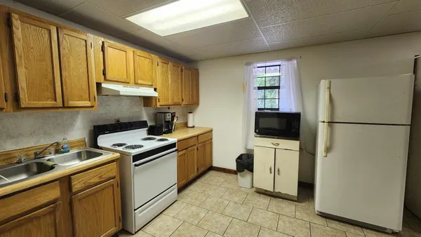 a kitchen with a refrigerator sink and cabinets