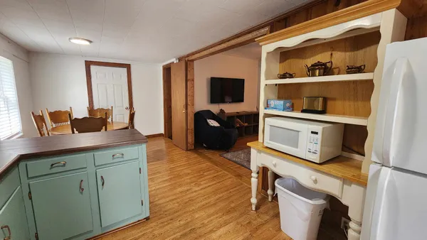 a kitchen with cabinets and wooden floor