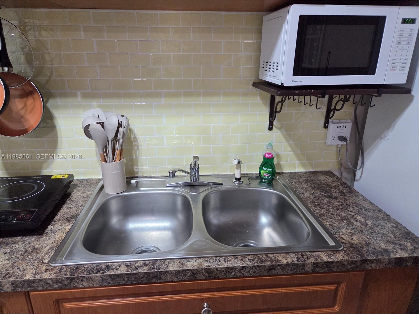2931 Southwest 135th Avenue Miami, FL 33175 - Photo 11 of 20 a kitchen sink with granite countertop a sink and a stove