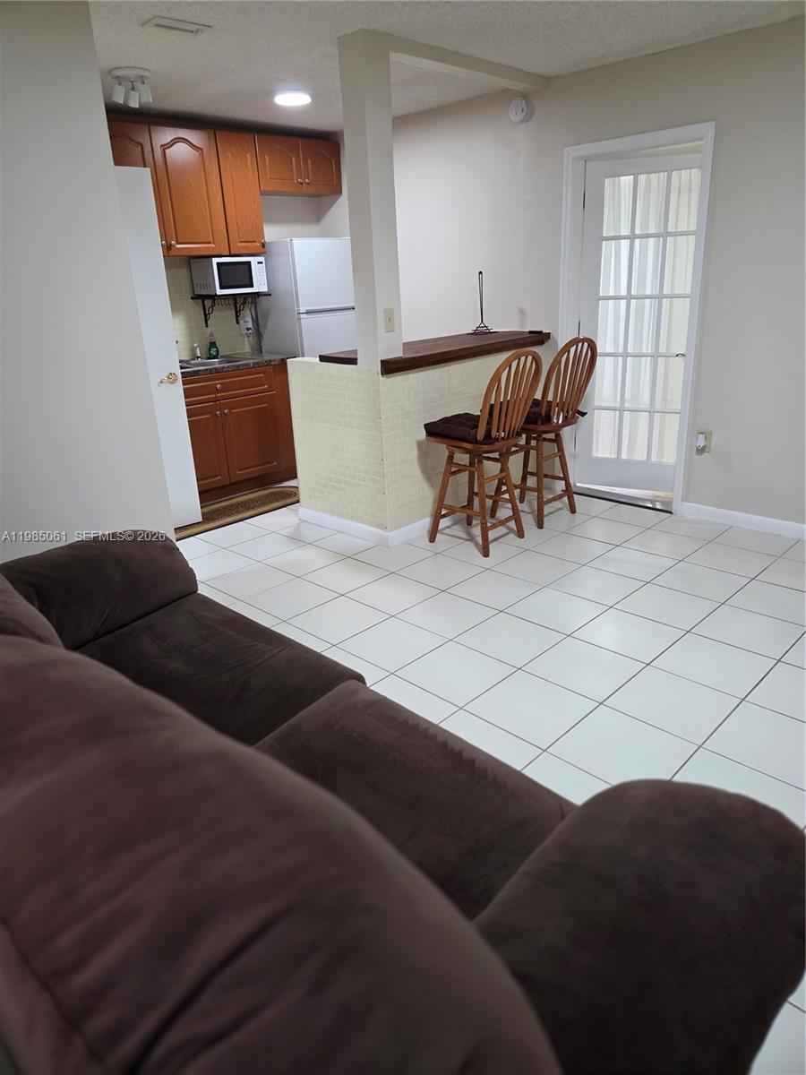 2931 Southwest 135th Avenue Miami, FL 33175 - Photo 4 of 20 a living room with furniture a dining table and chairs with wooden floor