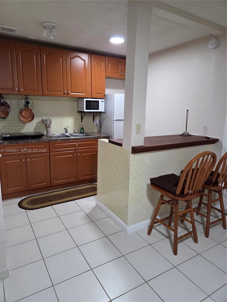 2931 Southwest 135th Avenue Miami, FL 33175 - Photo 8 of 20 a kitchen with stainless steel appliances granite countertop a sink and cabinets